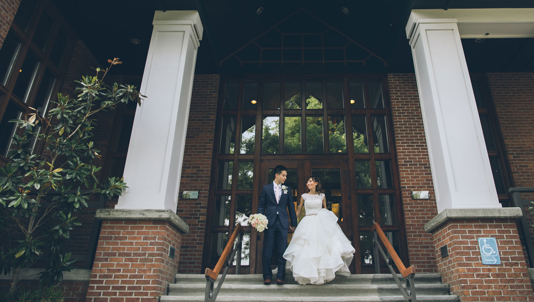 bride and groom holding hands on front doorstep of the lodgelike hotel Kimpton RiverPlace in Portland