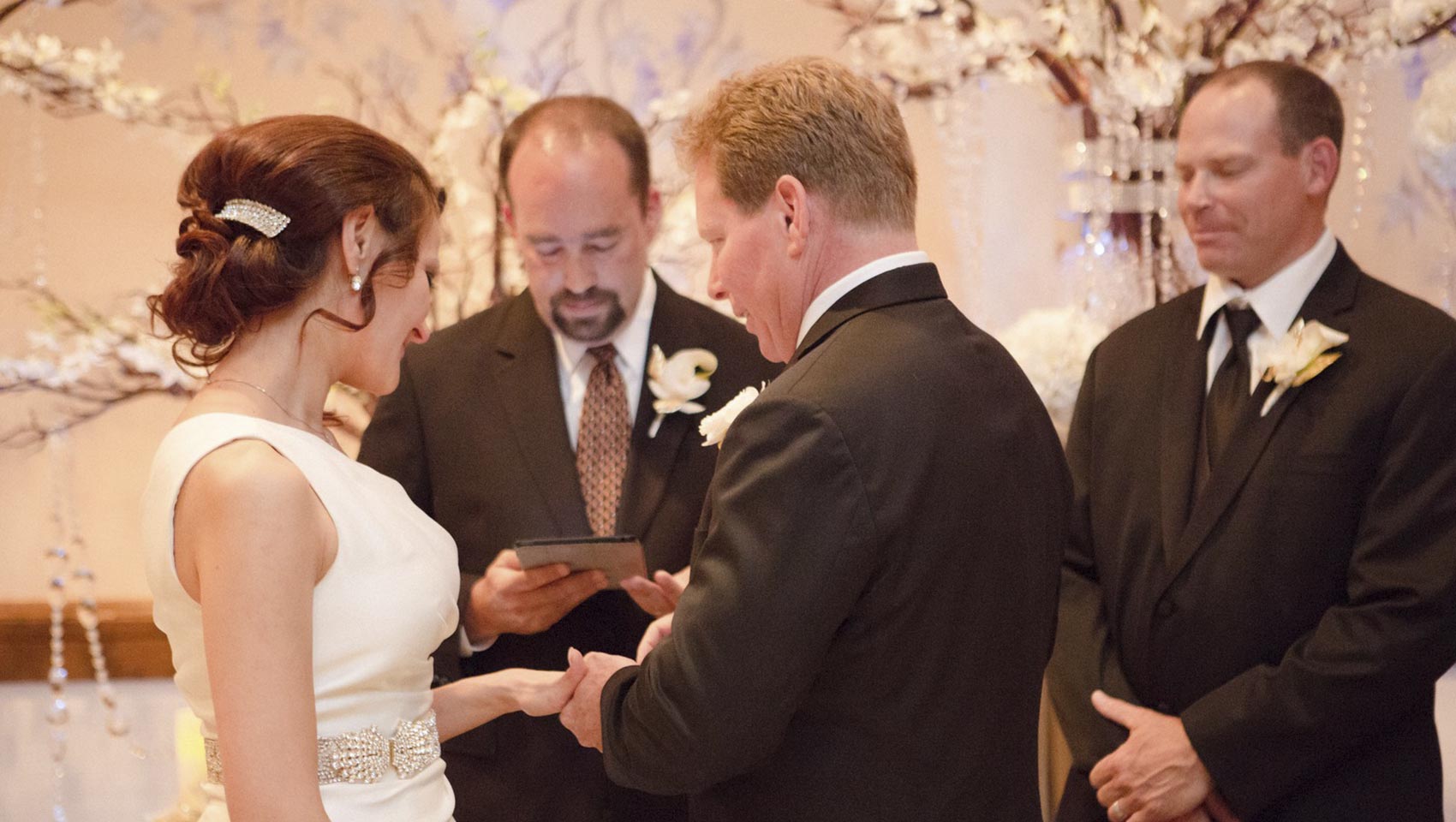 groom placing ring on bride at wedding ceremony