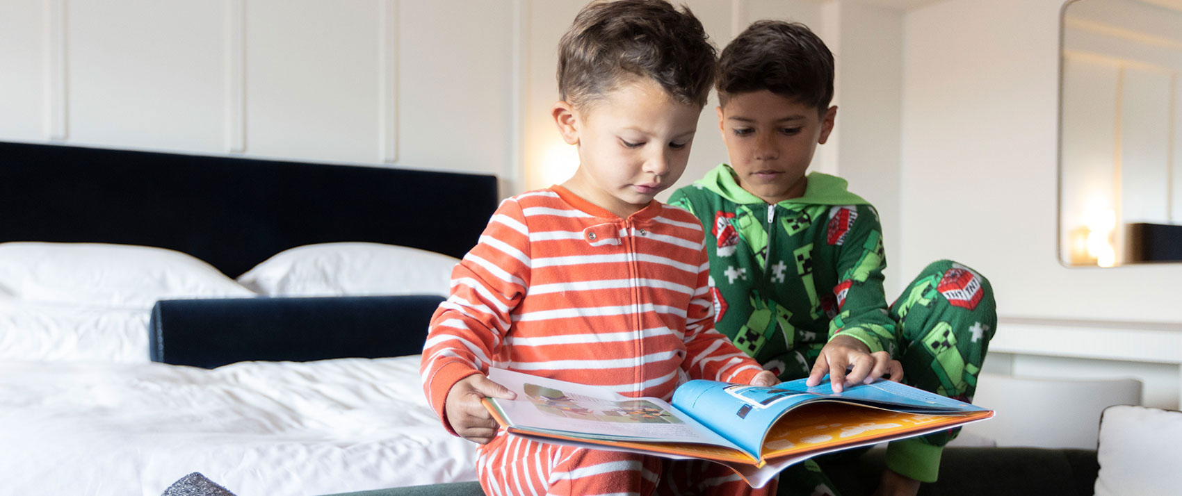 Two boys reading on a bed